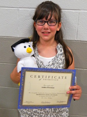 Showing off her certificate and her signature owl. Each year the 5th graders get a plush animal they pass around to each other and sign their names.